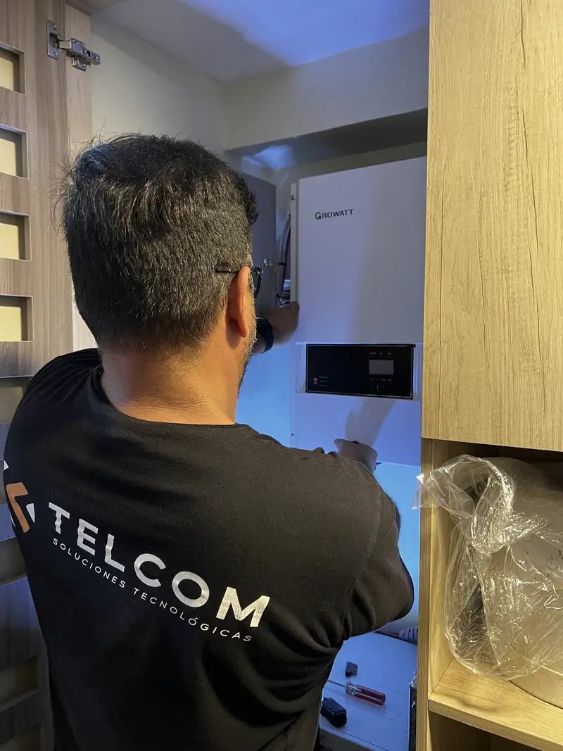 Técnico de Telcom instalando un inversor híbrido Growatt en una vivienda